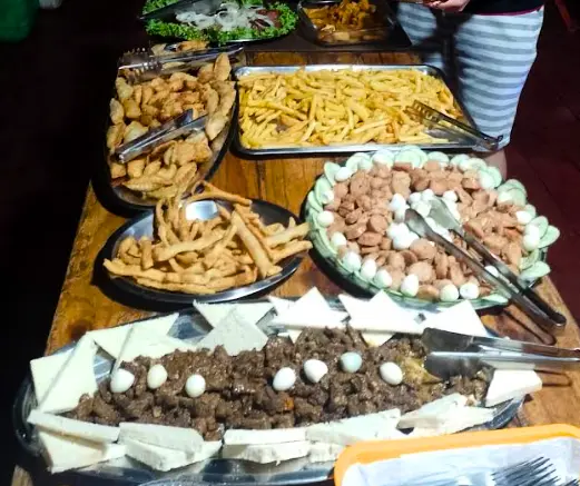 Buffet da pousada com batatas fritas, carnes e petiscos