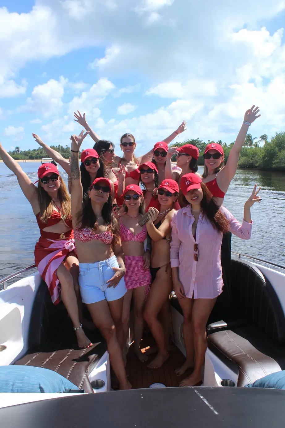 Donas comemorando a bordo de uma lancha em Caraíva