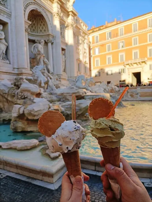 Duas casquinhas de gelato erguidas diante da Fontana di Trevi, em Roma