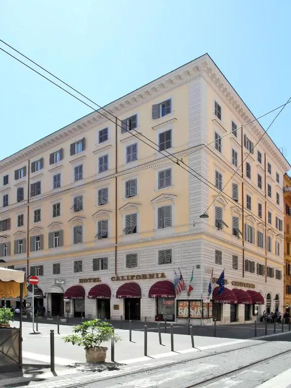 Fachada do Hotel California em Roma, prédio de esquina com toldos vermelhos