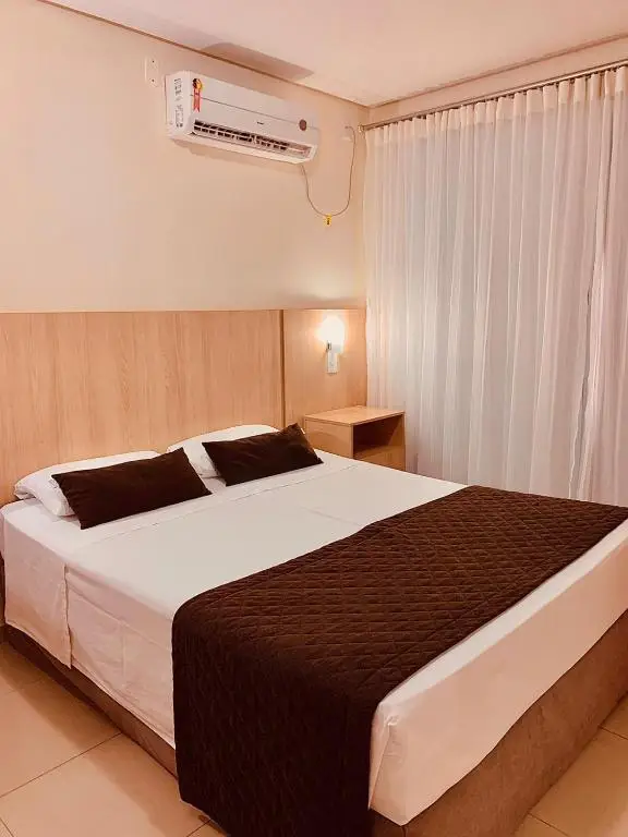 Quarto do hotel com cama de casal e ar-condicionado
