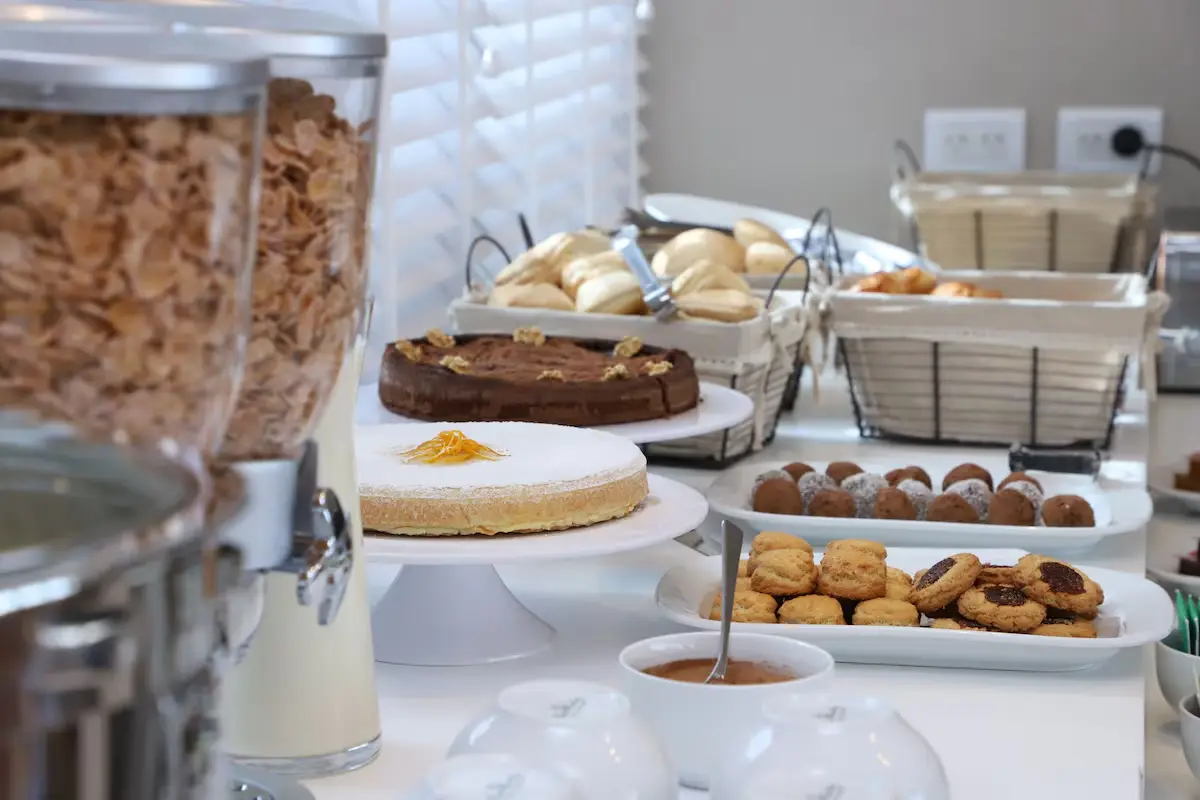 Mesa de café da manhã do hotel com bolos, doces e cereais