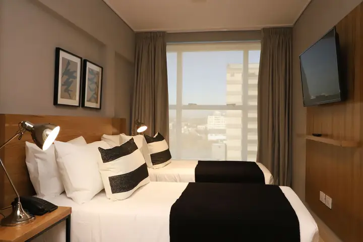 Quarto do hotel com duas camas e janela ampla