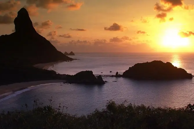 Pôr do sol dourado sobre o mar e uma ilha em Fernando de Noronha