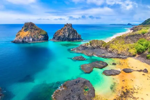 Vista do alto do mar azul-turquesa e das formações rochosas de Fernando de Noronha