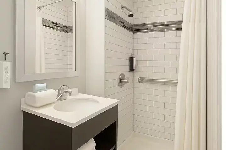 Banheiro do hotel com box e azulejos brancos