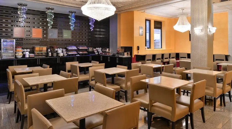Salão de café da manhã do hotel, com mesas e lustres