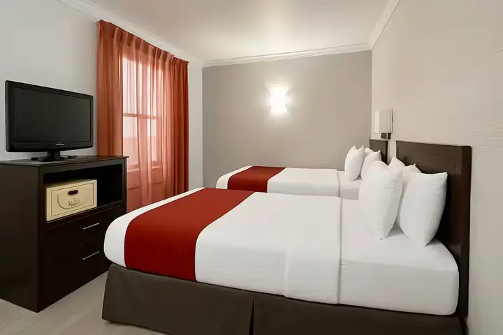 Quarto do hotel com duas camas de colcha vermelha