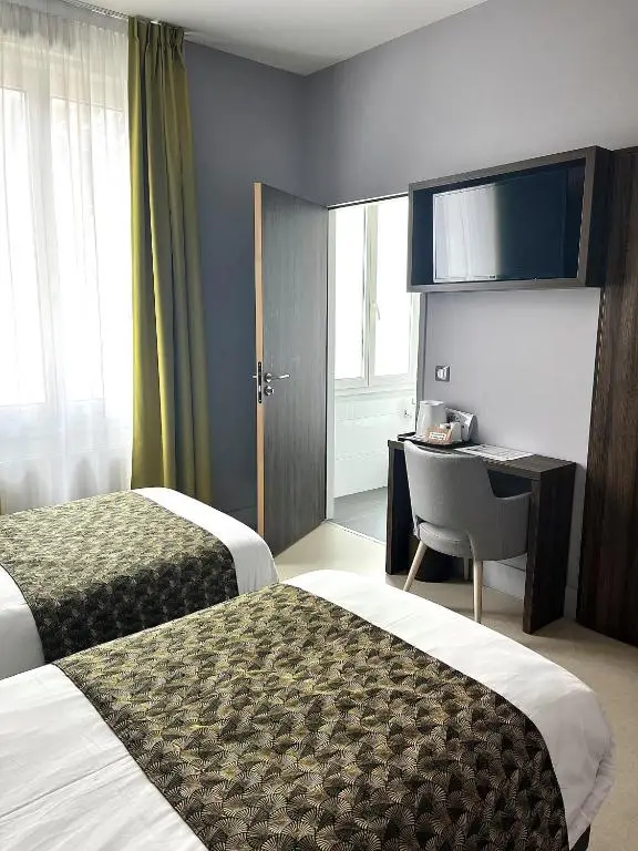 Quarto duplo do hotel com duas camas, escrivaninha e televisão